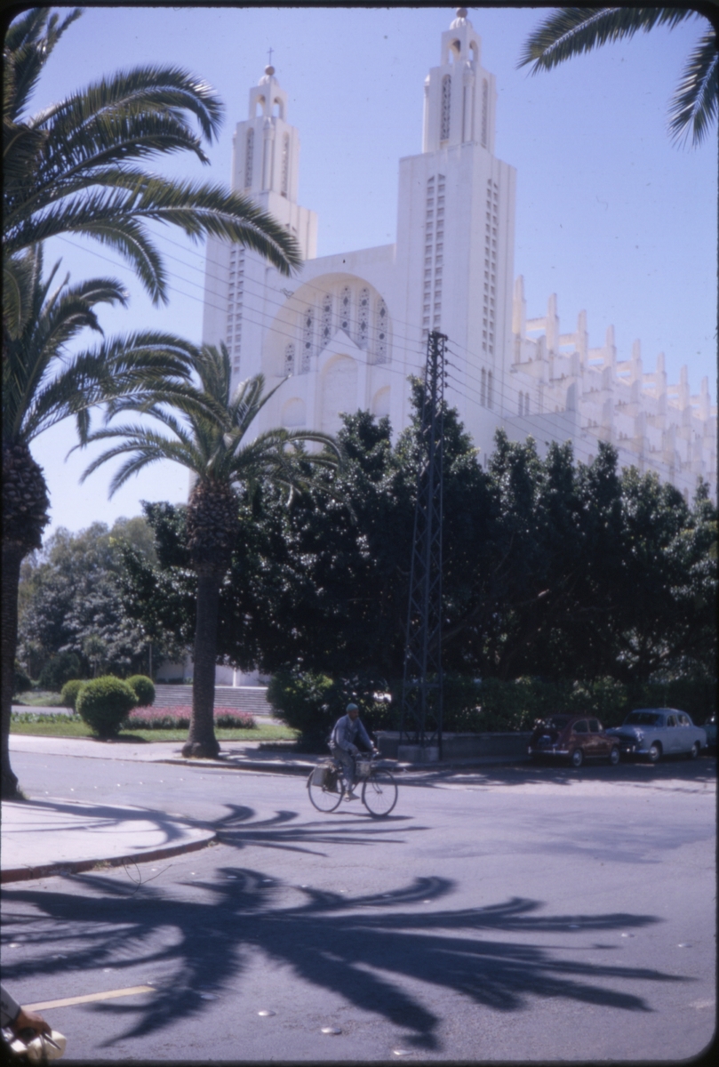 Syklist og palmer foran katedralen i Casablanca, Marokko. 'Sagafjord' Spring Cruise to Europe 1966.