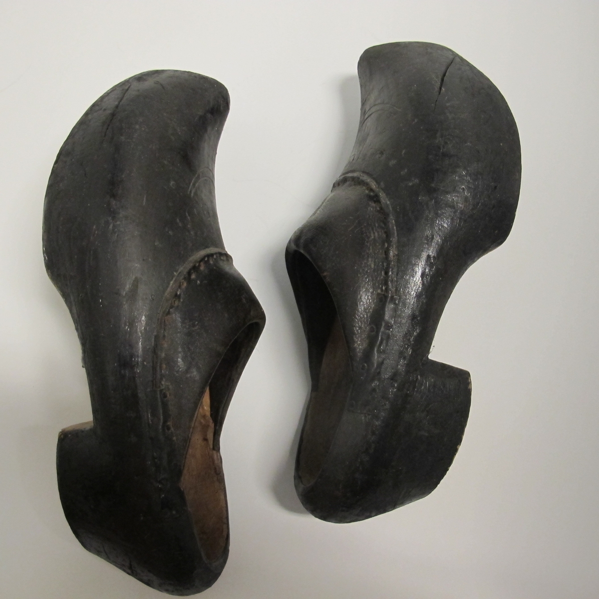 Skoene er sorte, med tre i bunn og i deler av kappen, der tuppen gå opp i en spiss foran. Den har noen innrissninger som ikke er tydet. Bare stykket nærmest vristen er av lær.