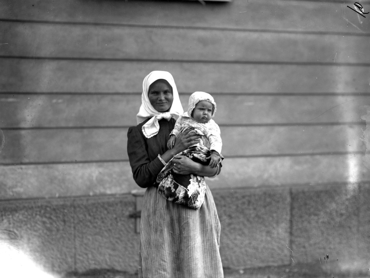 En kvinna med barn från svenskbyborna är fotograferad utanför kasernen på Ryhov i Jönköping 1929.
