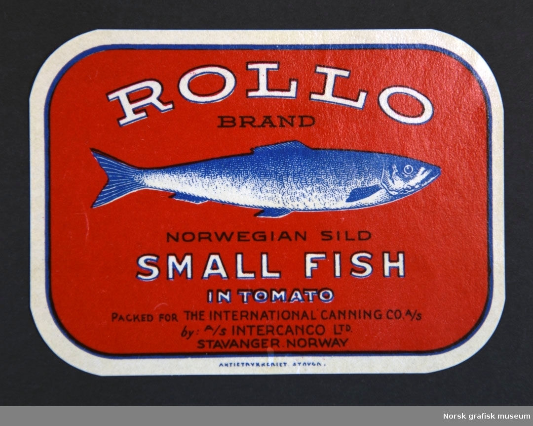 Rød etikett med en illustrasjon av en fisk midt på. 

"Norwegian sild small fish in tomato"
