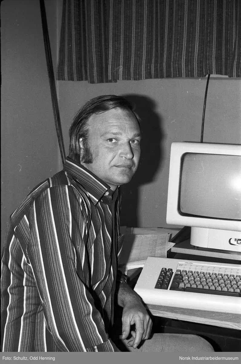 Portrett av mann som sitter ved en datamaskin.