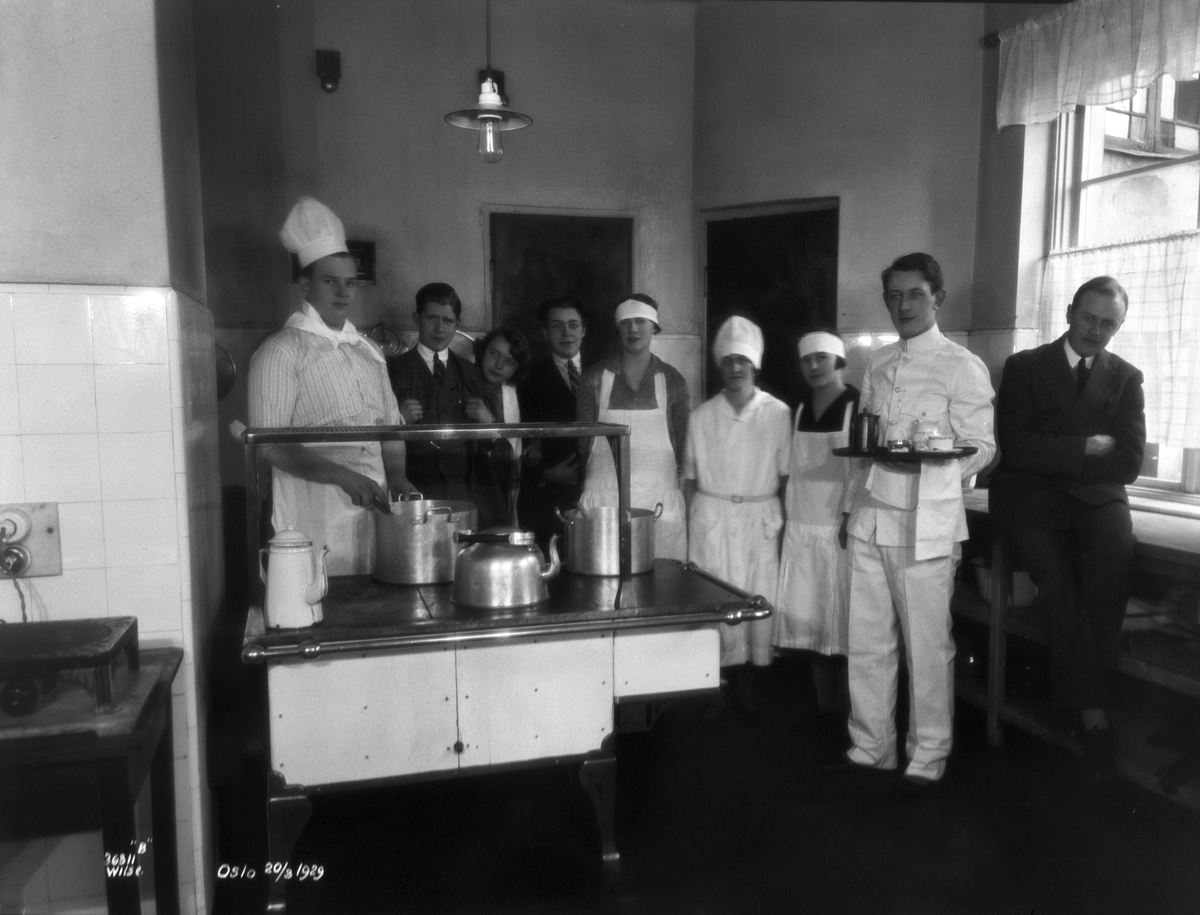Elver og kokk ved komfyr, Norsk hotellfagskole. Fotografert 1929.