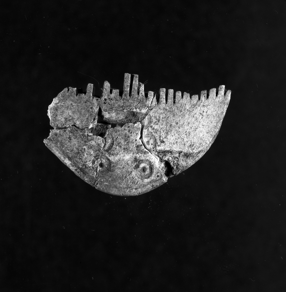 En benkam i horn som hittats vid en arkeologisk undersökning av ett gravfält i Byarum i Vaggeryds socken. Beskrivs som två tandplattor med passning, linje- och punktdekor.  Fyndnummer JM55938:753.