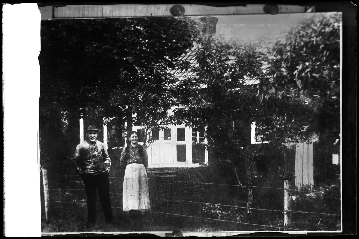 Äldre par framför hus