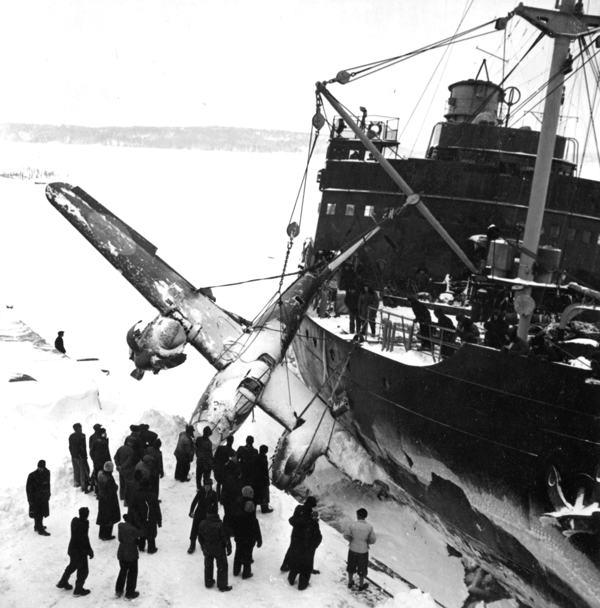 Bärgningsförsök av flygplan B 18B nummer 18172, Röd David i Härnösands hamn med isbrytaren Ymer efter nödlandning på isen den 10 februari 1946.