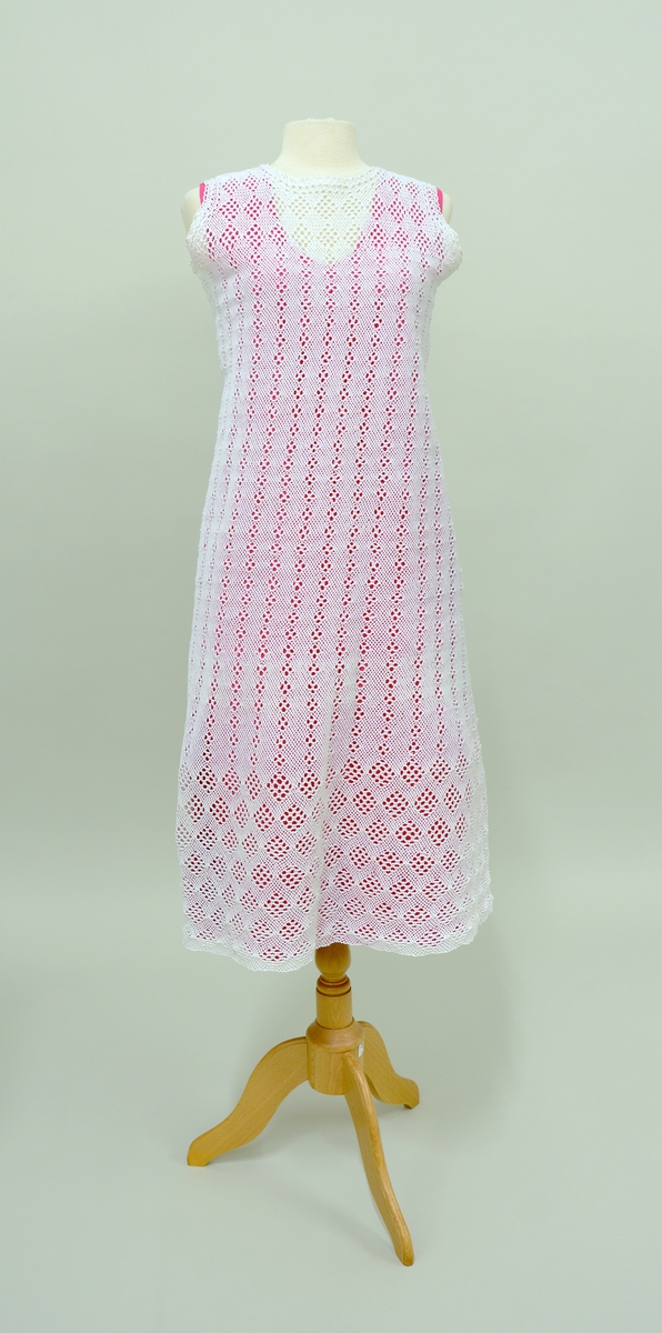 Kjole i tre deler: Kjole:TGM-BM.2000:083.A  Underkjole: TGM-BM.2000:083.B  Jakke:TGM-BM.2000:083.C
Kjolen har rund hals og ingen armer. Åpen jakke med lange ermer. Både kjole og jakke er utført  i telemarksbinding. Underkjolen er rosa og er laget av silke.