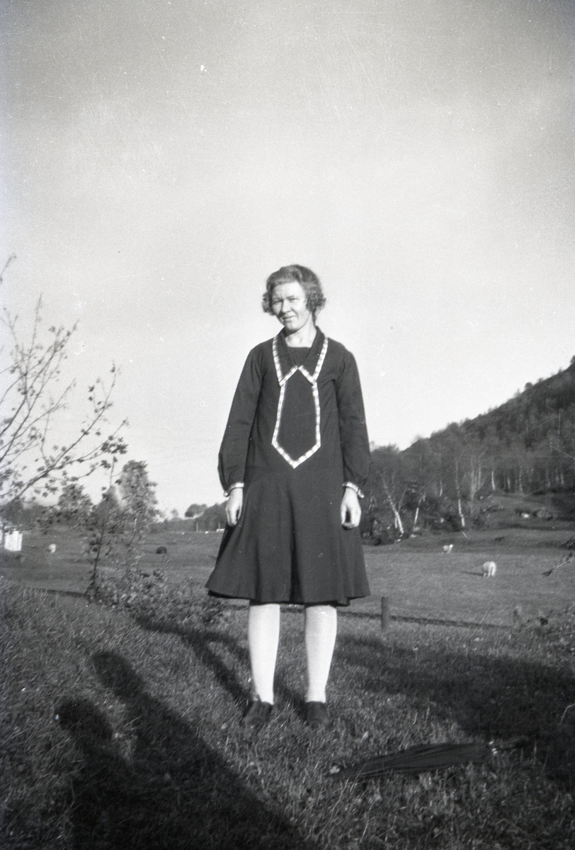 Portrettfotografi av ei kvinne foran ei beitemark.
