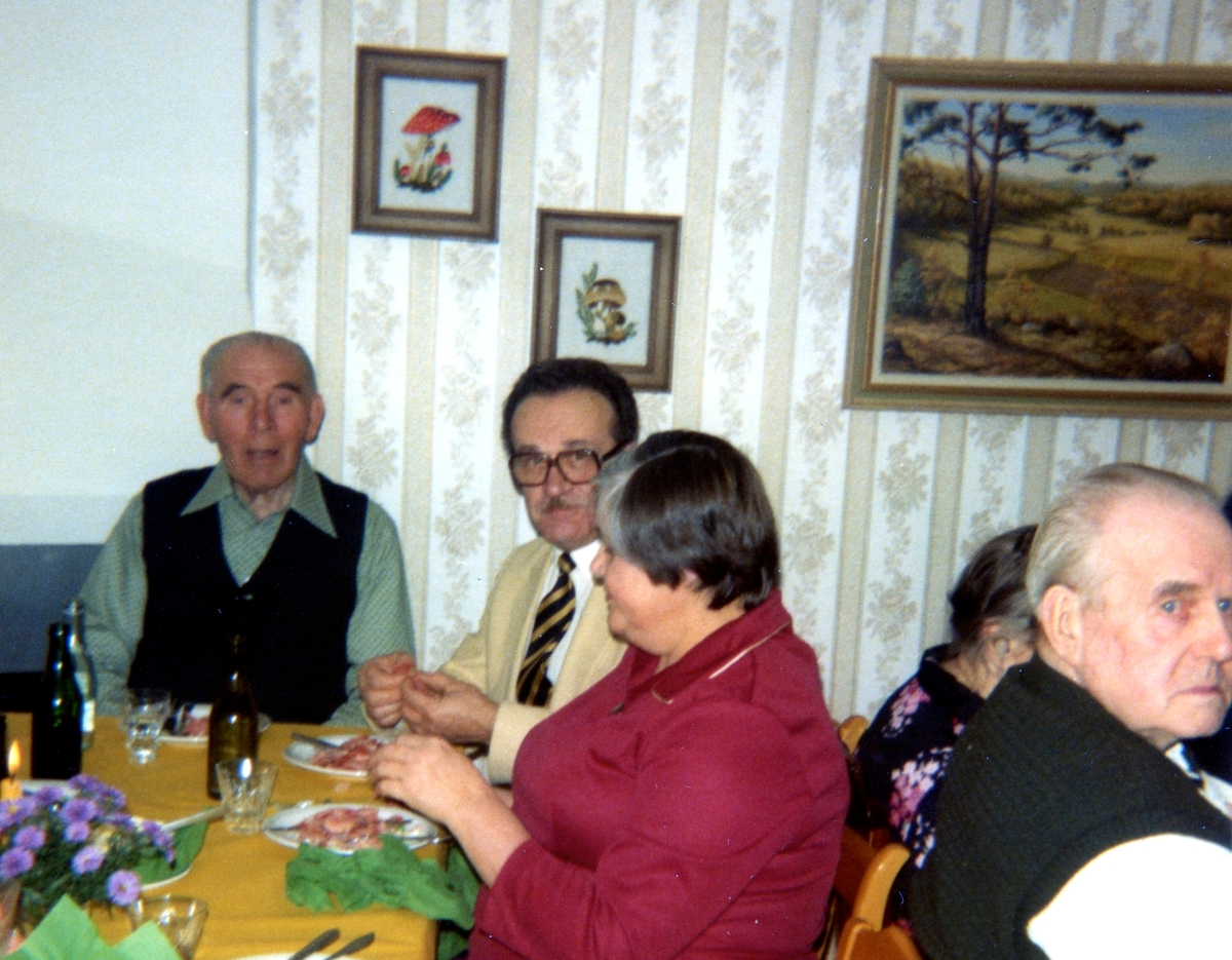 Räkfest för boende och anhöriga i Brattåshemmets matsal (Brattåsvägen 6) 1980-10-16. Sittandes från vänster: Kondratij Krivtsov (född 1895 i Ryssland, död 1985 i Kållered), anhöriga Nikolaj Babkin och Nina Babkin (dotter till Kondratij Krivtsov). Övriga är okända.