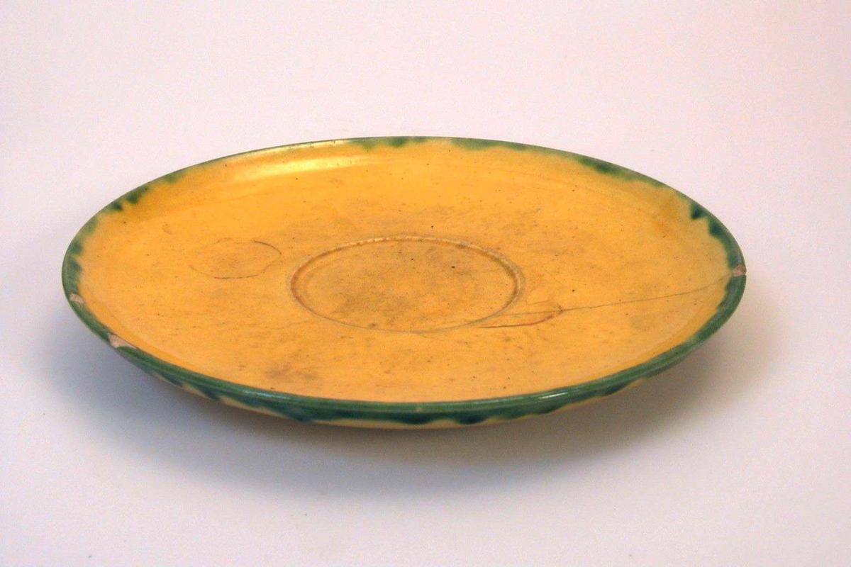 Skål i gul keramikk med grønn dekor. Brukskunst.