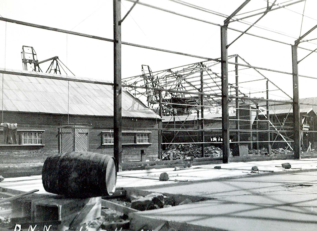 "12/04-1924" Nitriden. Bygging av stekeribygning for steking av elektrodekull. Jernkonstruksjopner. Tjæretønne og lagerbygning for ferdigvarer til venstre. Kraner på kai i bakgrunnen.