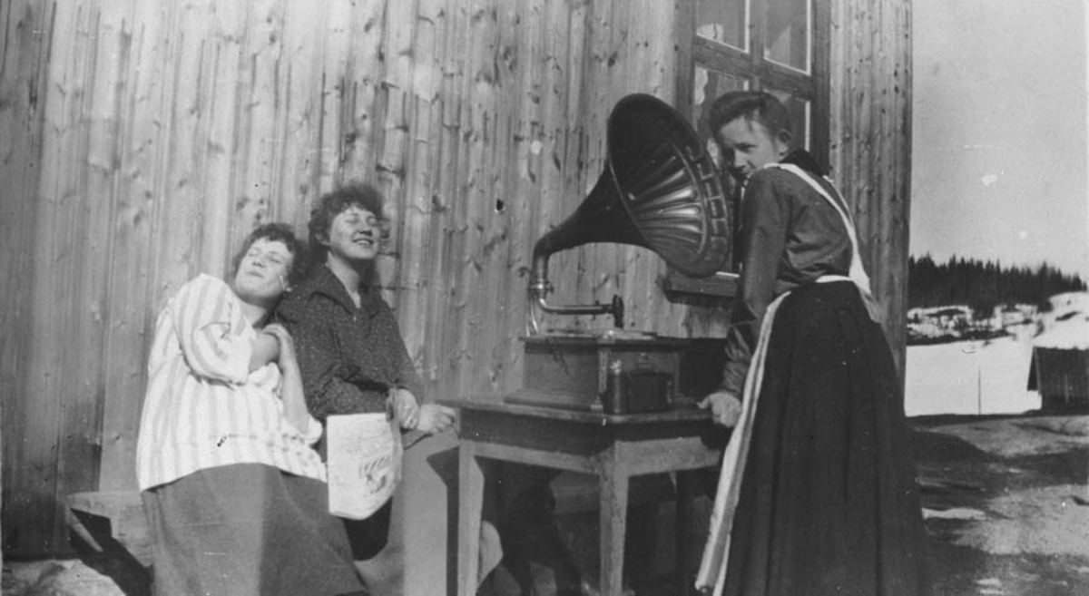 3 kvinner koser seg med gammel "trakt" grammafon.