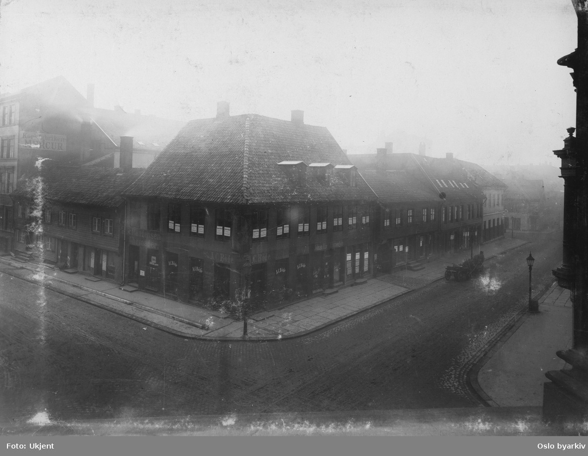Gatemiljø, fra Kirkegata. A.C. Böge, Kirkegata 28. Stadsingeniøren - Fotografier af Kristiania (albumtittel). Ca 1892, basert på øvrige daterte bilder i samme album.