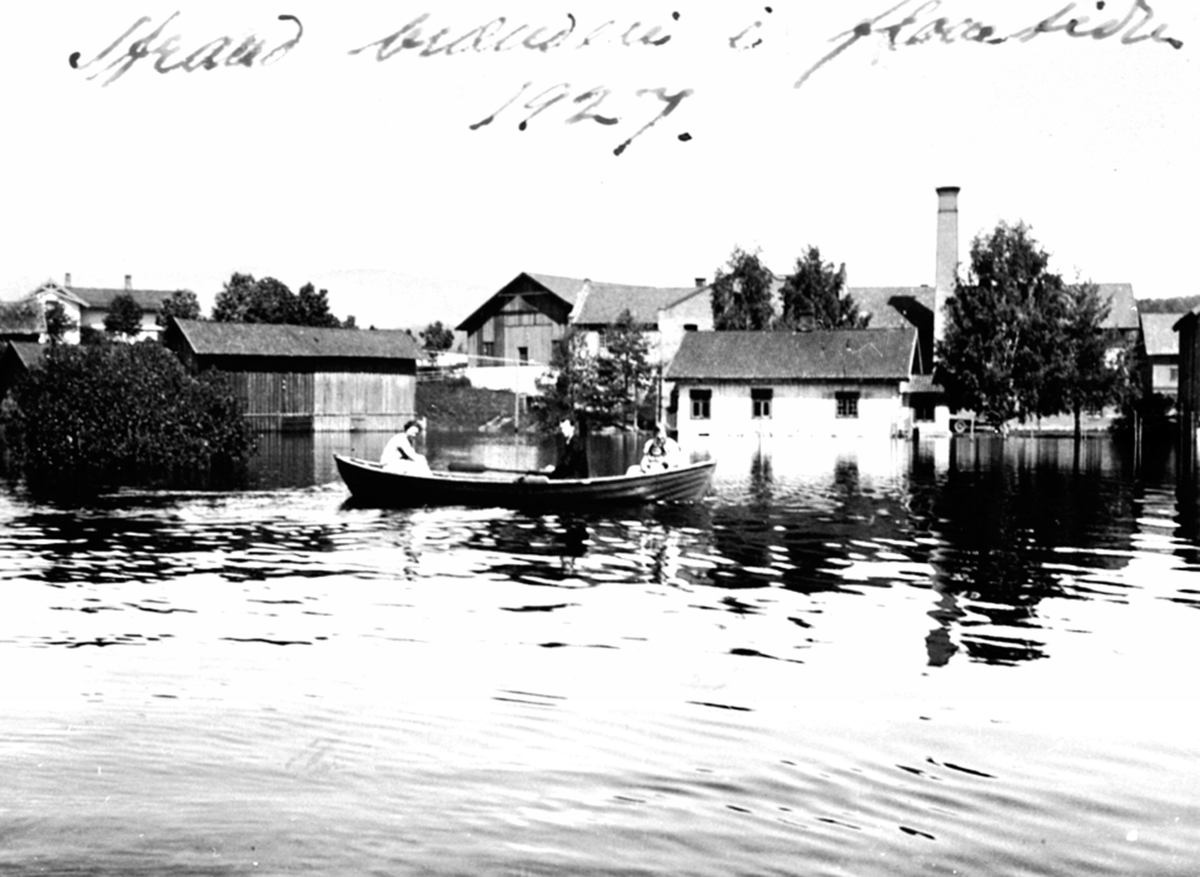 Familie i robåt, Strand brenneri, Moelv, Ringsaker. Flom i Mjøsa 1927.