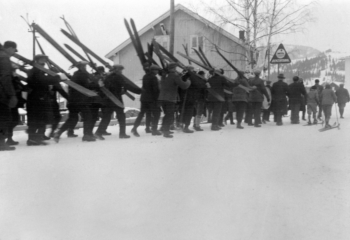 Gubbeskirenn, menn bærer på ski, marsjerer ved kvernveita, Buttekvern mølle, Brumunddal.