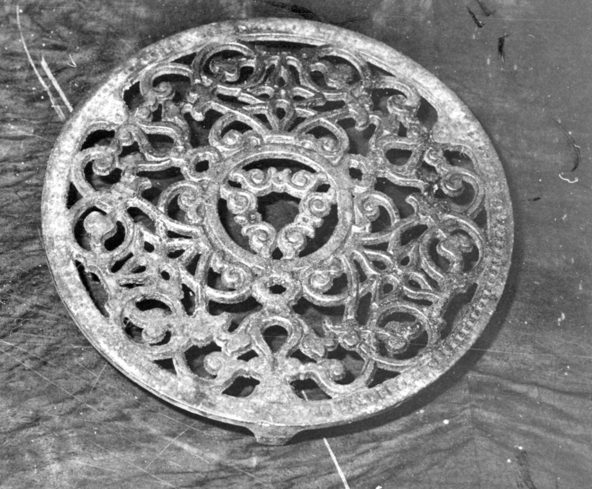 Bordskåner av støpejern, rester av sølvmaling, rund, gjennombrudt mønster, tre føtter