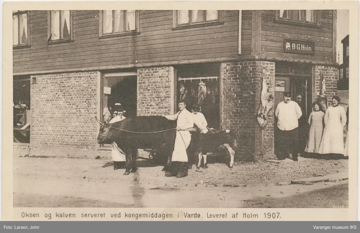Okse og kalv og fem personer foran B.G. Holms slakteforretning
