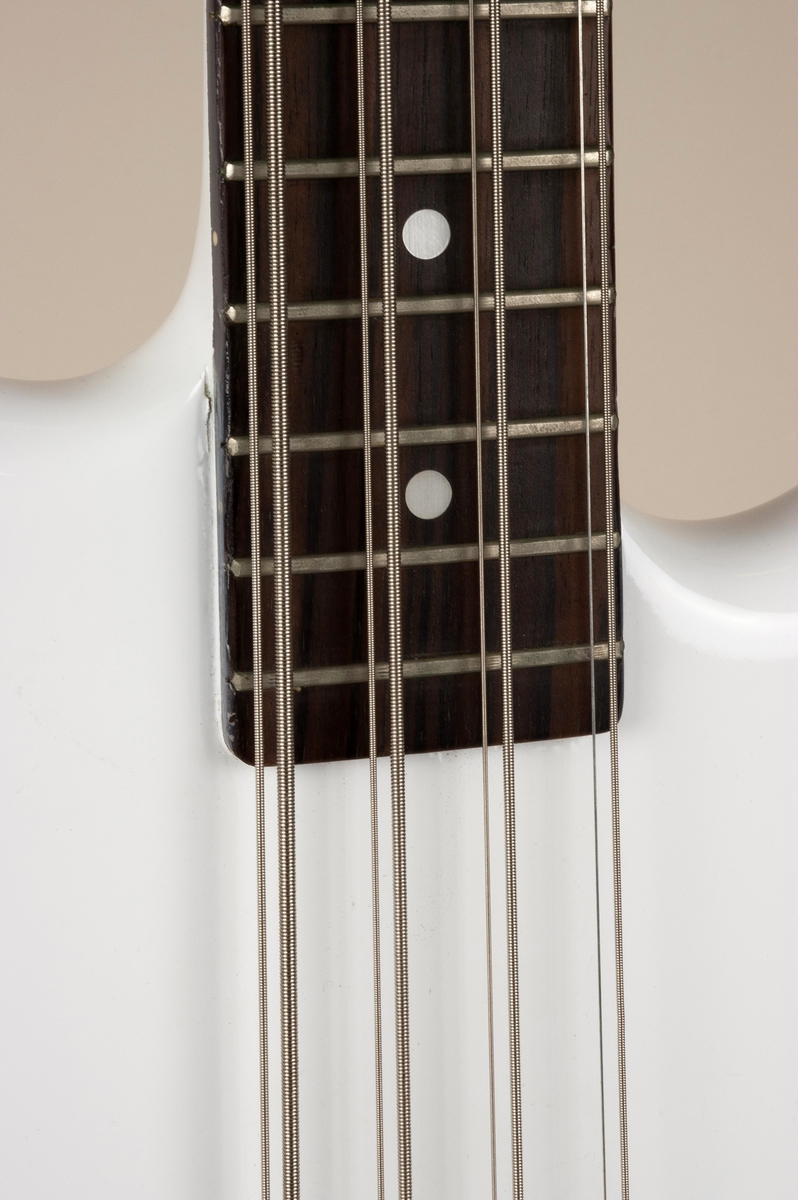 Elektrisk bassgitar med åtte strenger: fire tykke med tilhørende store stemmeskruer og fire tynne med tilhørende mindre stemmeskruer.  To OBL-pickuper.