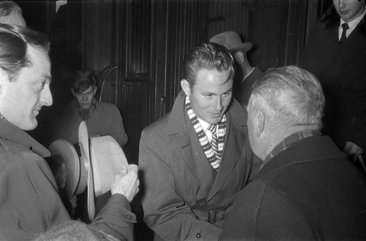 Egil Danielsen kommer hjem til Hamar etter å ha vunnet Olympisk gullmedalje i Spyd i Melbourne 1956. Hamar Jernbanestasjon. Han blir ønsket velkommen hjem av rådmann Sigurd Pedersen. 