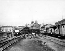 Stasjonstomta på Østbanen med godsvogner og jernbanefolk