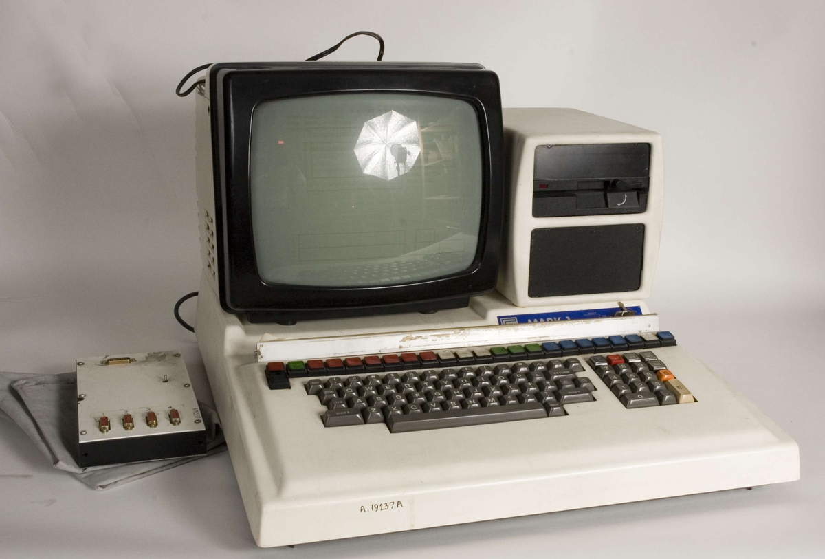 Består av:
A: Maskin med tastatur
B: Diskettstasjon
C: Skjerm
D: Plate med datakontakter til fordeling
