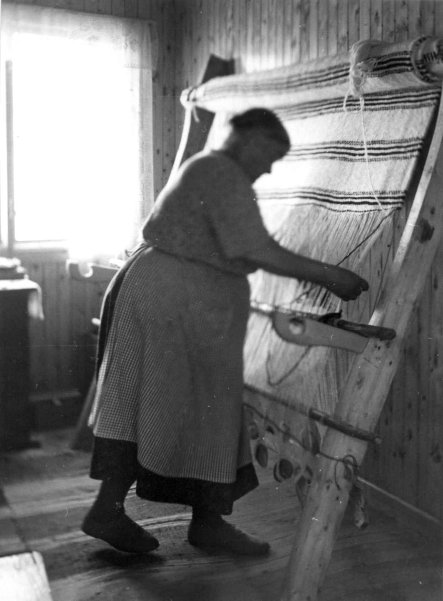 Greneveving (25). Anne Hansen vever på greneteppe. Manndalen 1955.