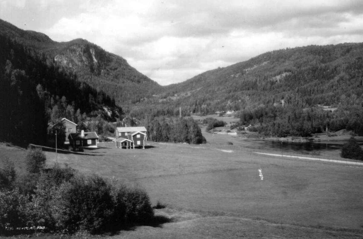 Landskap, Buskerud. 1930. Oversiktsbilde med gårder, vei, elv og skog. Åser i bakgrunnen.