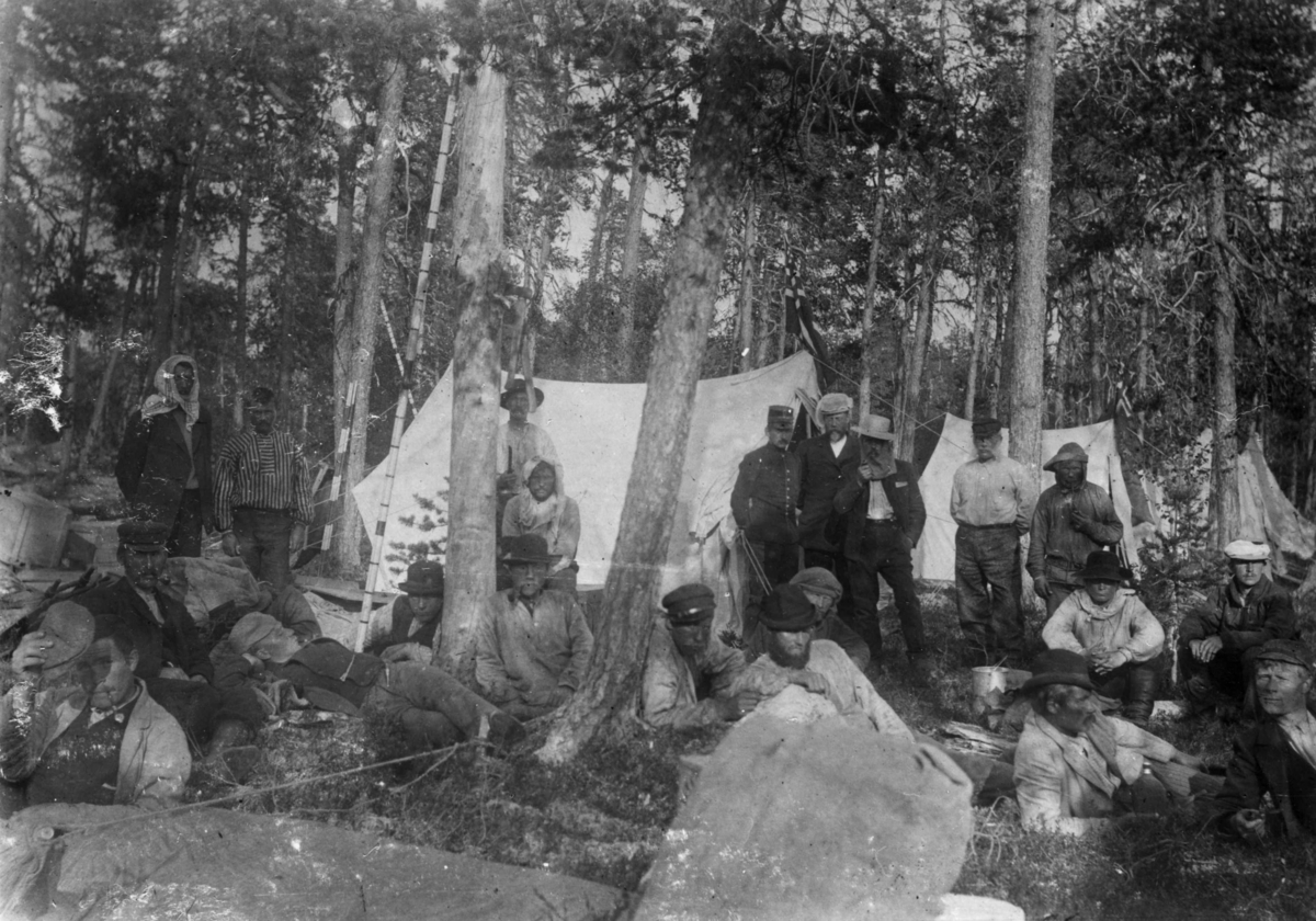 Fra grenseoppgang i Sør-Varanger, Finnmark, antatt 1897-1899. Gruppe menn samlet ved teltplassen.