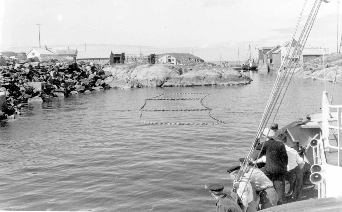 Båter og bebyggelse i Ona i Sandøy i Møre og Romsdal. Fiskere har satt garn under sildefiske.