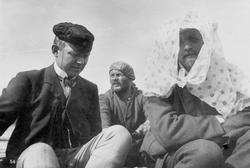 Portrett av tre studenter i båt på Pasvikelven.