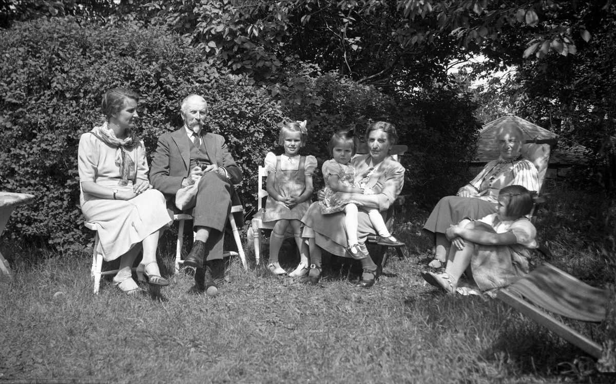 Dikka og Eyvind Arentz og Vilhelma Maling sitter i hagen sin i Åsly sammen med slektninger. Fotografert 1936.