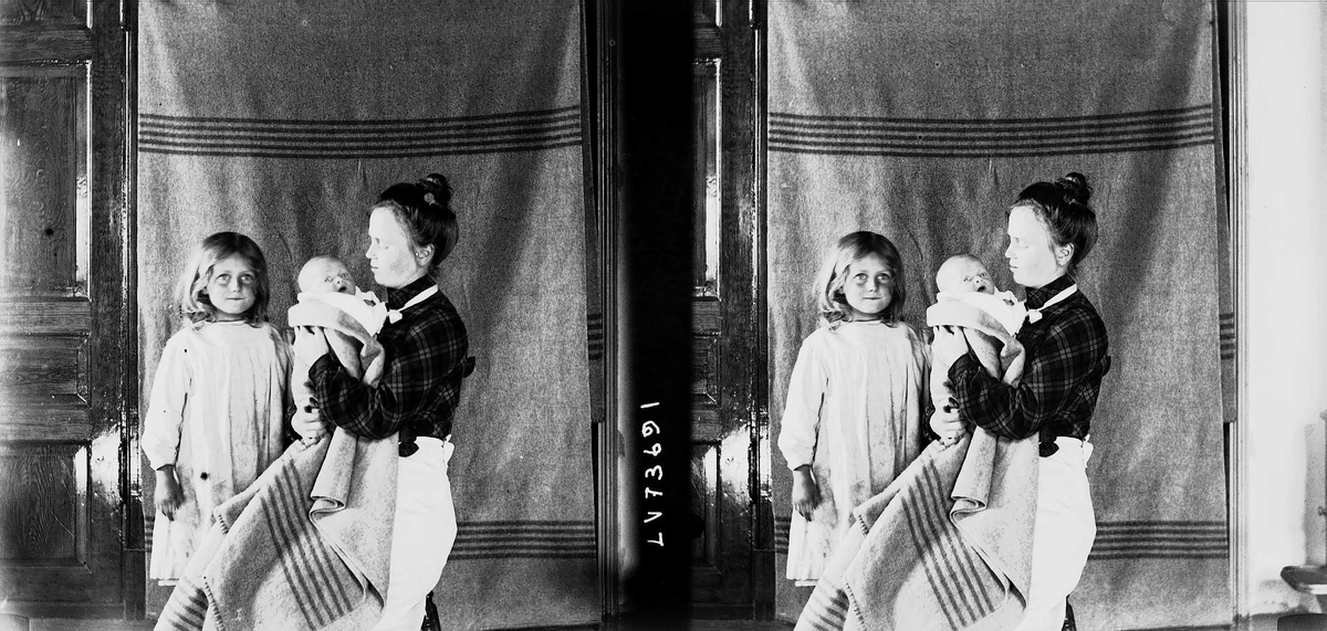 Familiemedlemmer fotograferes, Nedre Digerud, Frogn, Akershus, 1902. Mor Margrethe Q. Wiborg med to av barna foran opphengt bakteppe.