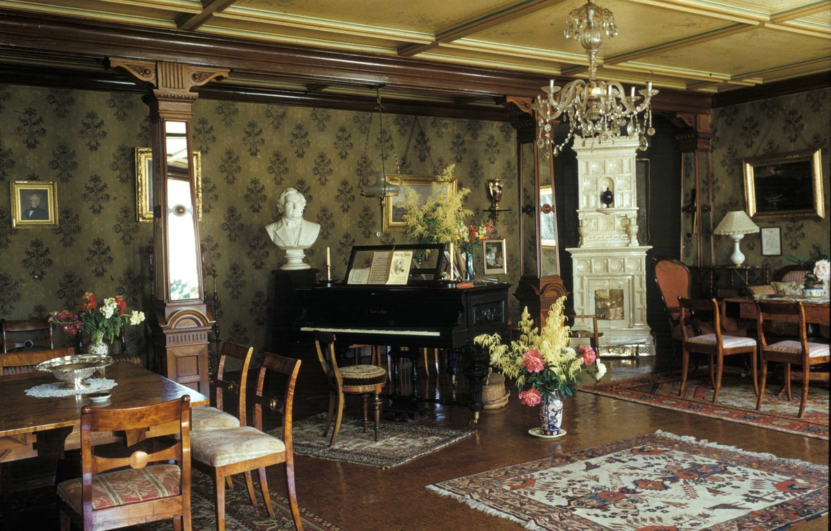 Sælid, Hedmark. Stue med interiør, piano, byste, kakkelovn, stoler og bord.