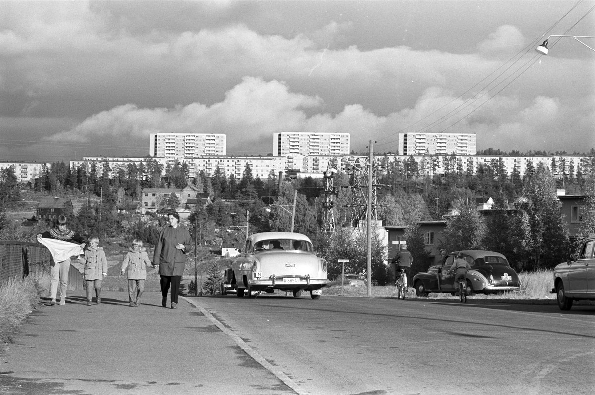 Alle bilder tatt ved Abildsø krysset, Bogerud og høyblokkene på Bøler i bakgrunnen. Serie. Landeveismiljø med bebyggelse, biler og mennesker.