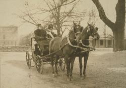 Sigurd Ibsen i uniform sittende i vogn med kusk.