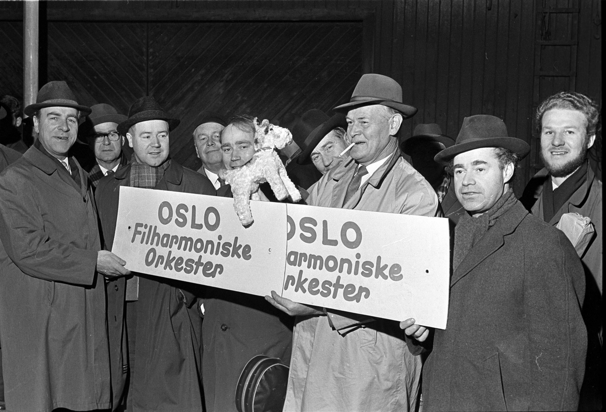Oslo Filharmoniske orkester hjem fra utlandet, mennsker med plakat, november 1962