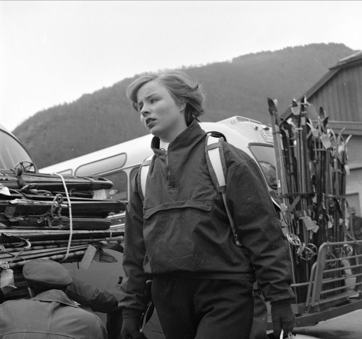 Otta, Sel, Oppland. Sportskledd kvinne med bagasje. Buss med ski.