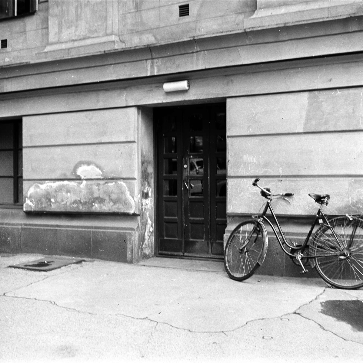 Karl Johans gate 47, Oslo, 09.08.1956. Universitetet. Inngangsdør og sykkel.