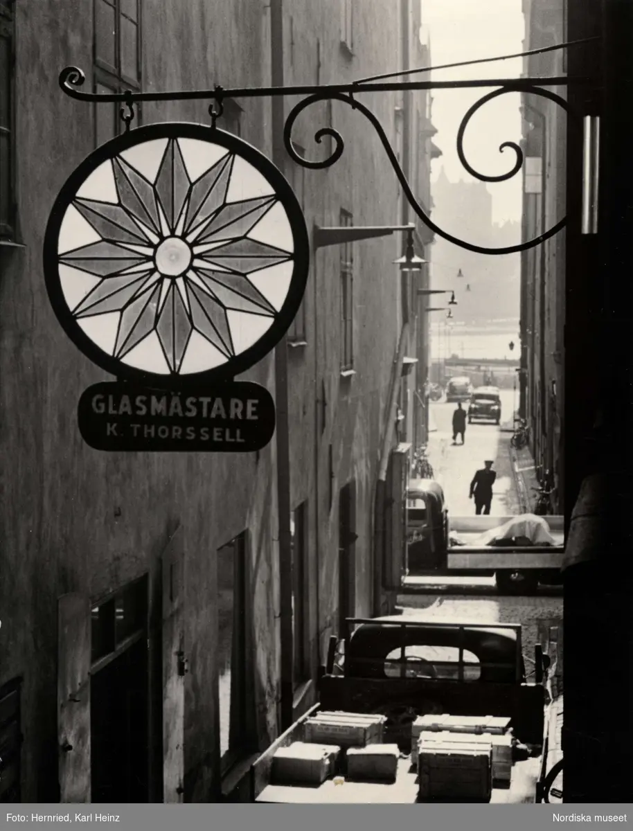 Skylt i smide och glas för glasmästare K. Thorssell i Gamla stan, Stockholm