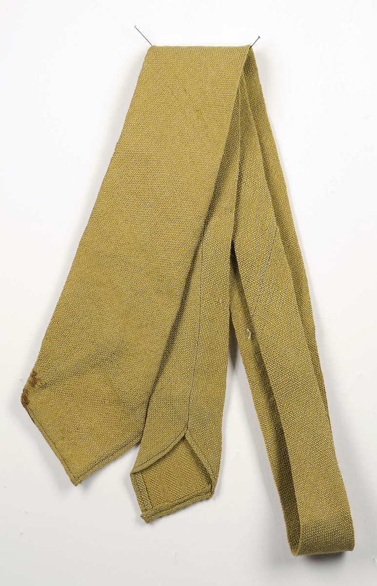 Gul slips vävd i tuskaft av ull och lin. Slipsen är märkt B-4167.