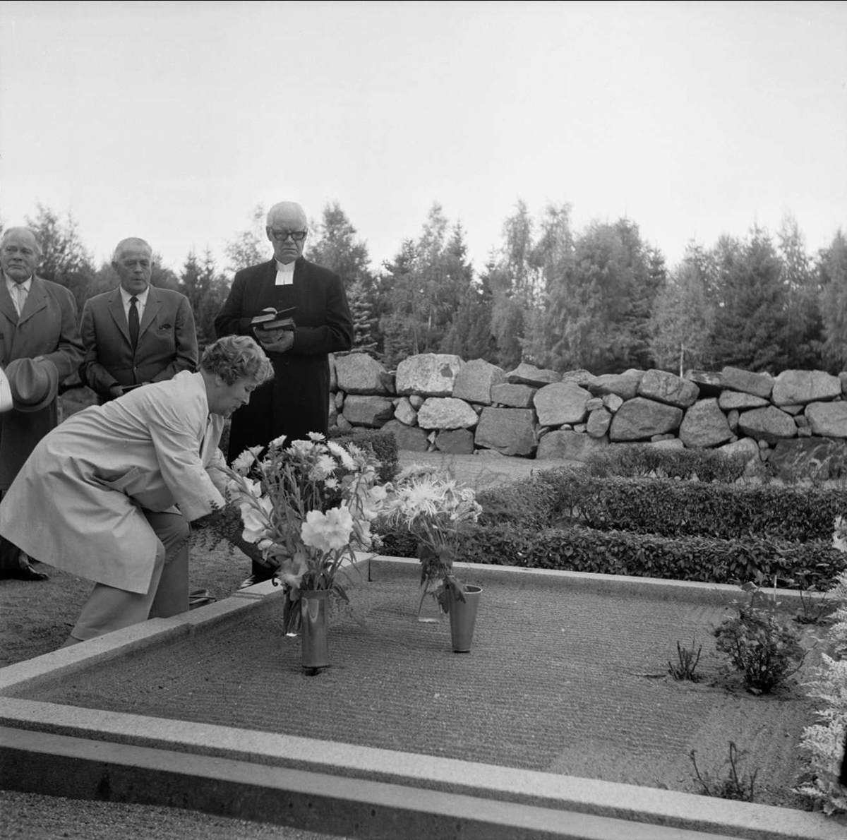 Släkt- och kusinträff på Tierps kyrkas kyrkogård, Uppland september 1972. Kvinna placerar blommor på grav