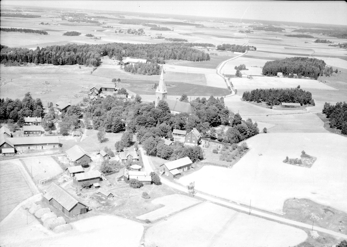 Flygfoto över Danmarks kyrkby med omgivande odlingslandskap, Danmarks socken, Uppland 1947