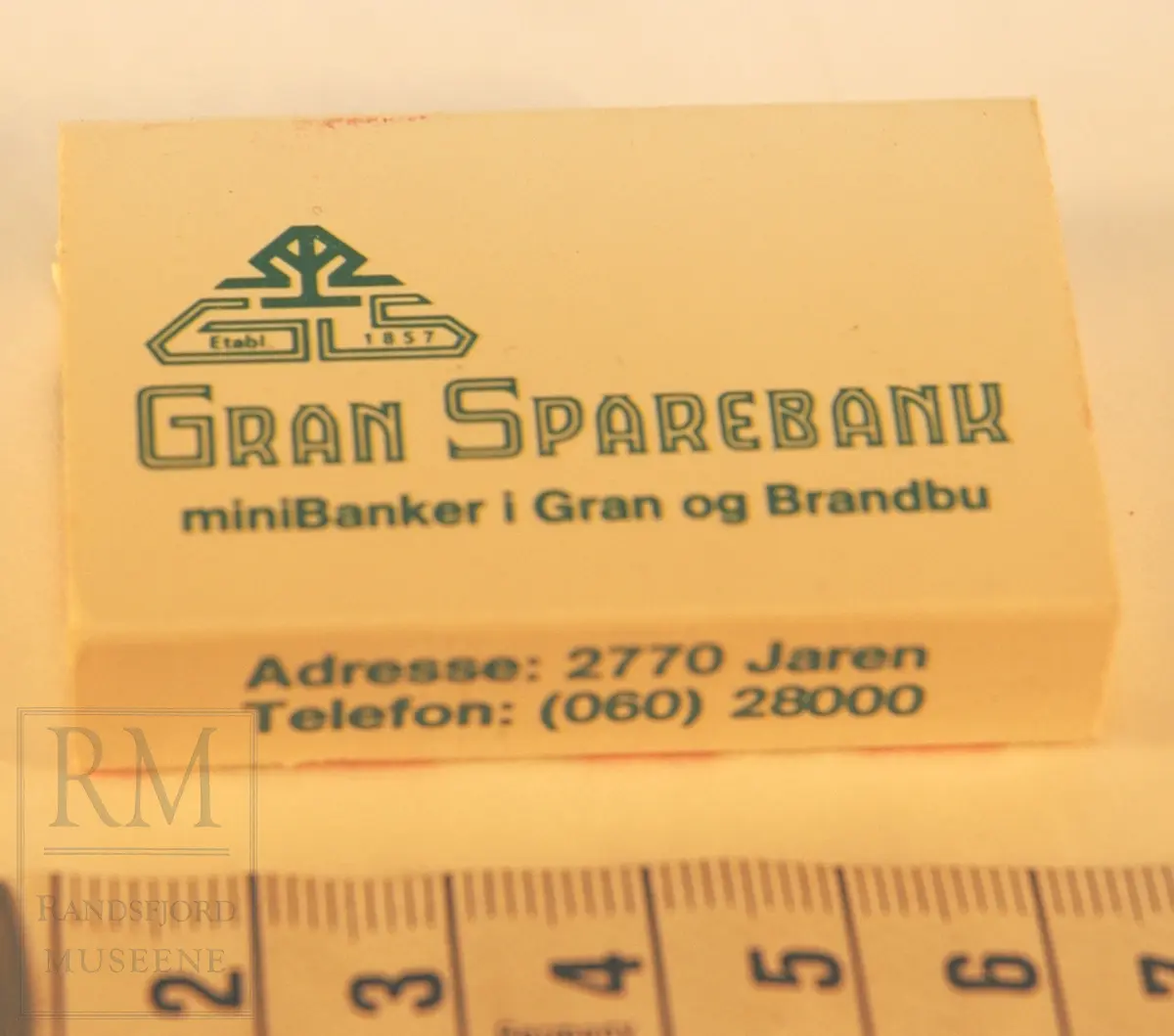 Reklameeske Gran Sparebank. Papp - hvit - brettet og limt sammen, med skuff med fyrstikker. Rivflate på en side. 