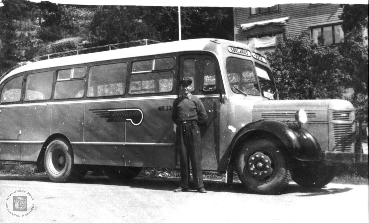Rutebuss.
Bussen er merket "Sørlandsruta". Dette selskapet ble stiftet i 1951 på grunnlag av mange mindre rutebilselskaper i regionen. Tidspunkt for fotografering er derfor tidligst 1951. Bussen kan selvsagt være eldre.