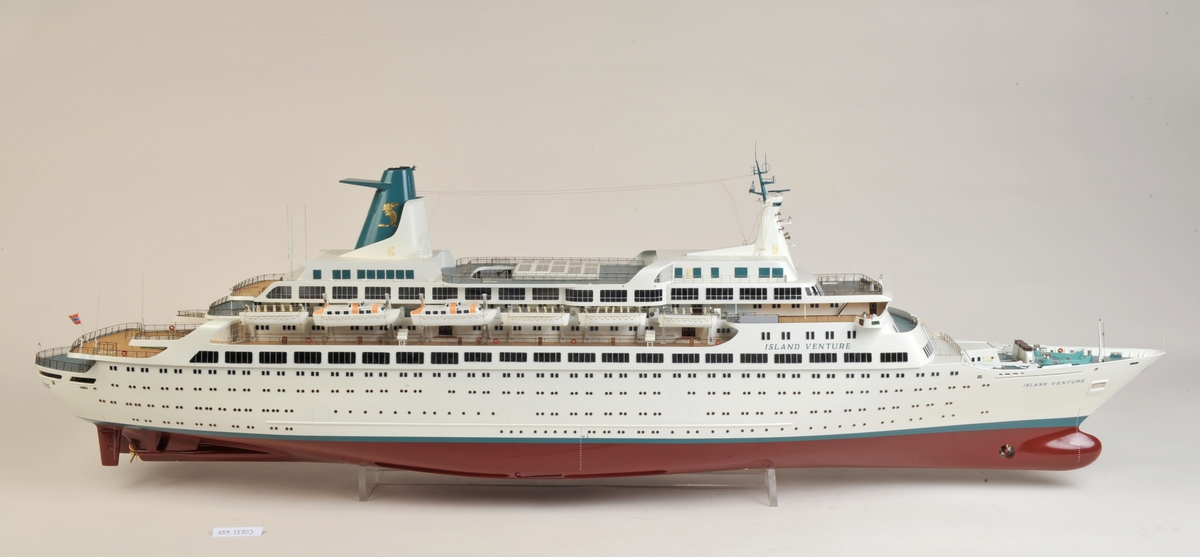 Hvitt passasjerskip med 6 livbåter på hver side, 2 av typen motorlaunche, rødt undervannsskrog, tynn grønn linje over vannlinjen, bvitt skrog, grønn skorstein med gyllen havhest.