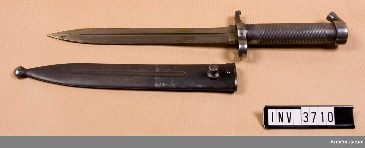 Knivbajonett m/1896 t gevär m/1896, m/1938/automatgevär m/1942.Består av: 1 bajonett, 1 balja av stål.Helt tillv. av stål med rörformigt lättrat grepp med konisk låsknapp och pipring. Rak, eneggad klinga med smal blodskåra på båda sidor. Klingb vid fästet: 25 mm. Pipringens id: 15,5 mm. Balja, l: 232 mm, vikt: 120 gr, tillv.nr 850.