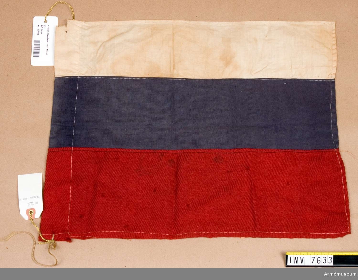 Tsarrysk flagga nedskuren från en roddbåt vid Torneälven söder Haparanda hösten 1915 av Carl von Heine, då underlöjtnant. Mått 360 x 450 mm, färg röd, blå och vit G A L. 

Samhörande gåva 7626-.