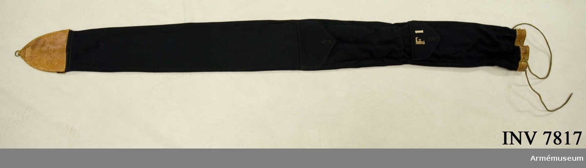 Fodral i mörkblått fint kläde och ljus läderskoning. Två fickor - en för kravatten och en för spetsen G V.  På den översta fickan står "F 1" i vit applikation.