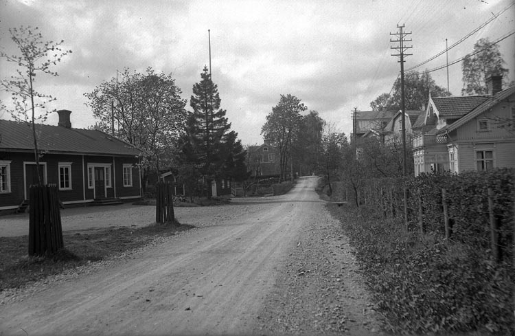 Enligt fotografens noteringar: "Lilla Torget vid Munkedals samhälle, fabriken i bakgrunden."