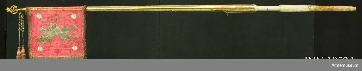 Duk av röd sidendamast med i guld broderat dubbelt G under sluten kunglig krona i guld och i yttre sidan östergötlands vapen, en grip i guld följd av fyra rosor i blått silke, runt kanten 60 mm bred frans av guld och rött silke, fäst med tre gula sidenband och förgyllda mässingsspikar. Banderoller -  snoddar - överklädda med galon av guld och silvertofsar av rött silke med insprängt guld.