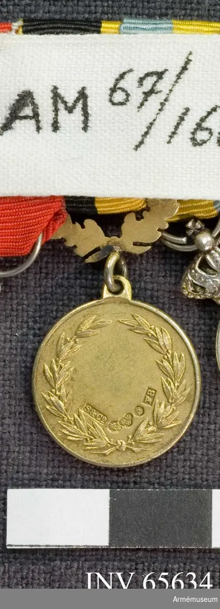 Grupp M II.
Åtsidan har ett vapen med en grip och öppen krona inom en öppen lagerkrans. Runt om SÖDERMANLANDS SKYTTEFÖRBUND". Frånsidan har en öppen lagerkrans samt fem kontrollstämplar. I namnstämpeln står "S & Co", i årsstämpel "F8". Medaljen hänger i en öppen eklövskrans. Medaljbandet är kluvet i svart och gult.